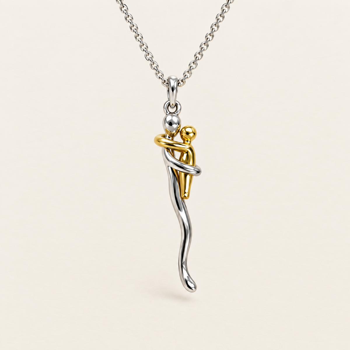 Knuffelketting: zilveren figuur die een klein gouden figuurtje omarmt, aan een zilverkleurige ketting